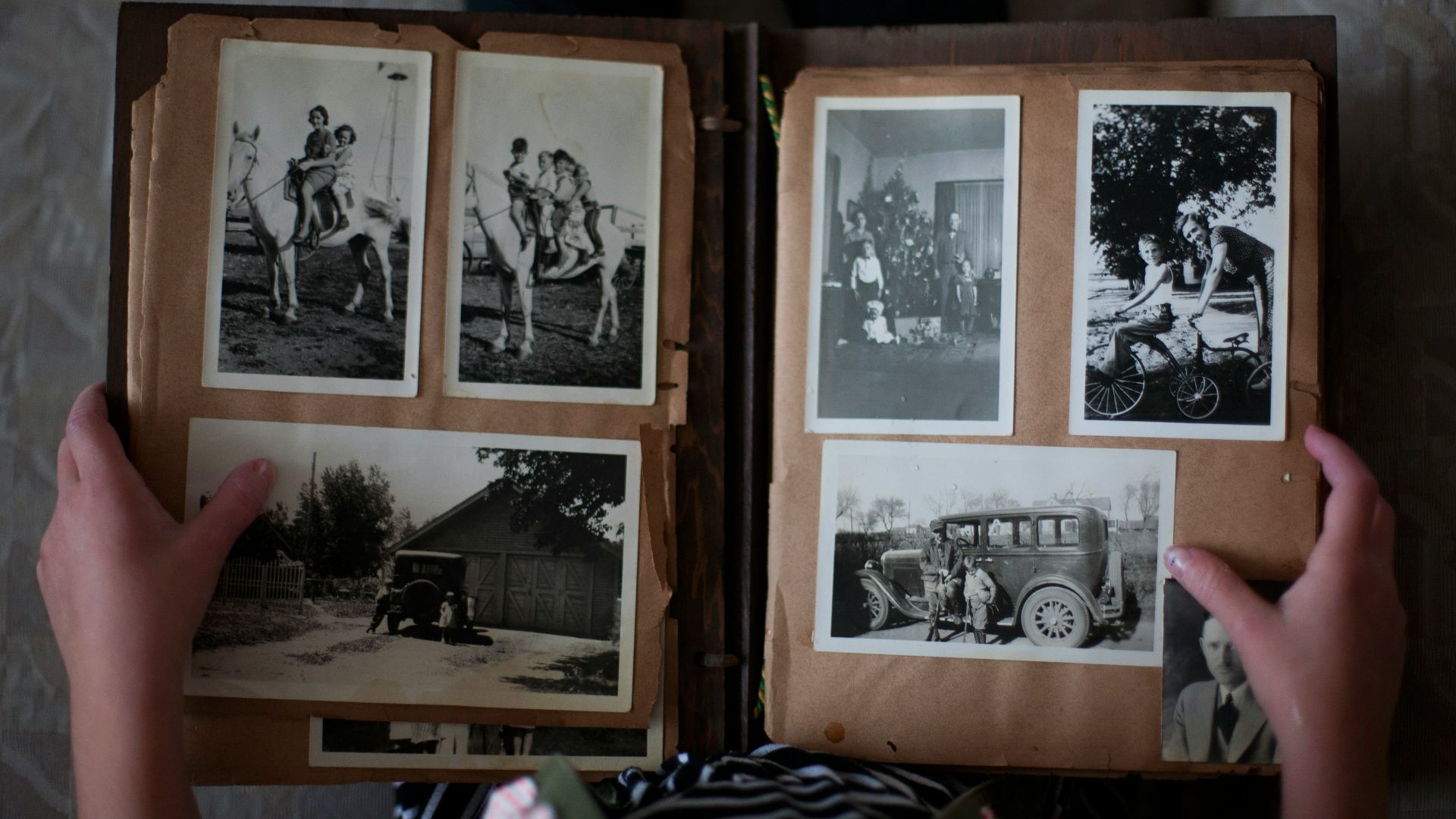 person opening photo album displaying grayscale photos