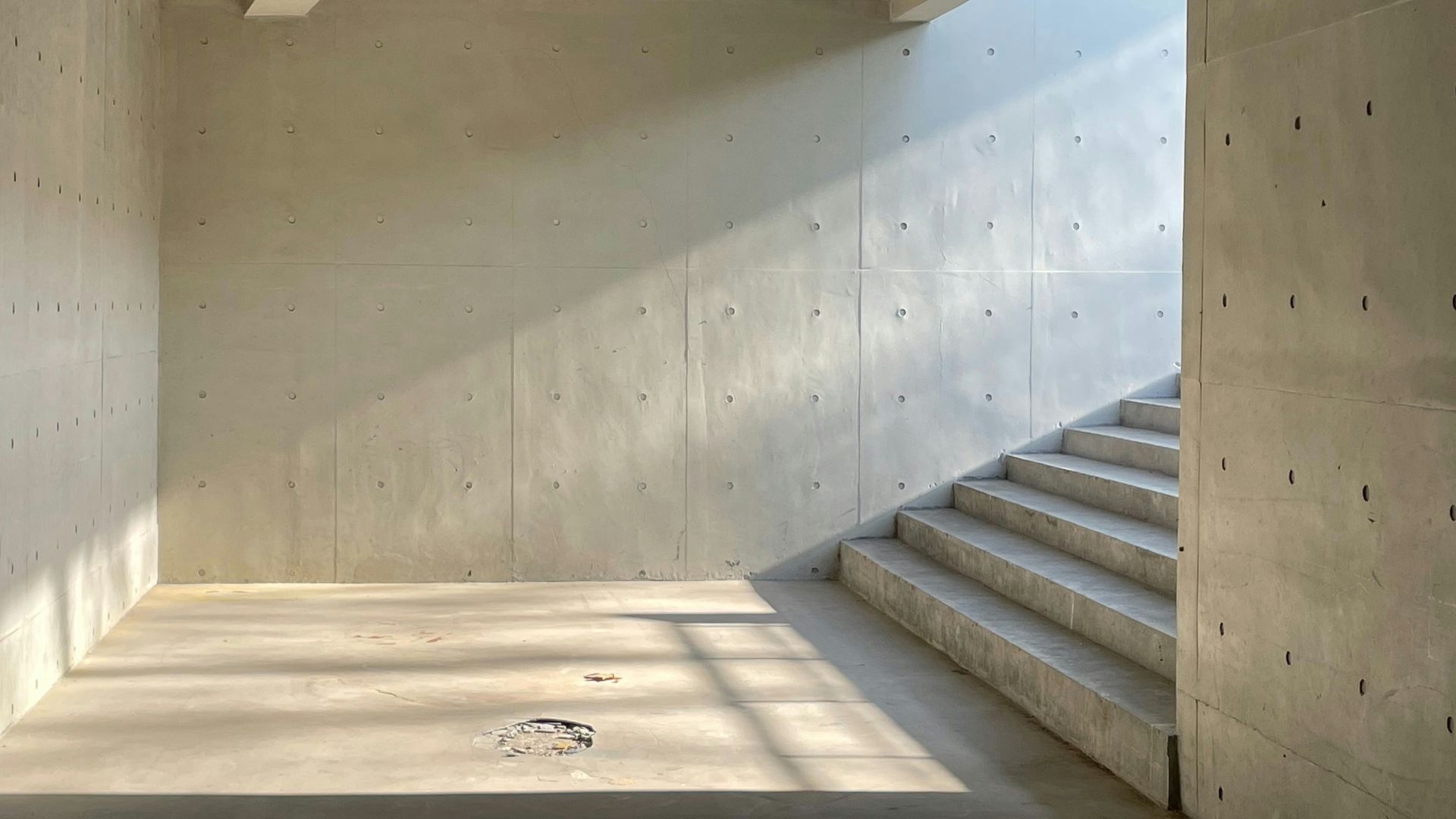 an empty room with concrete walls and stairs