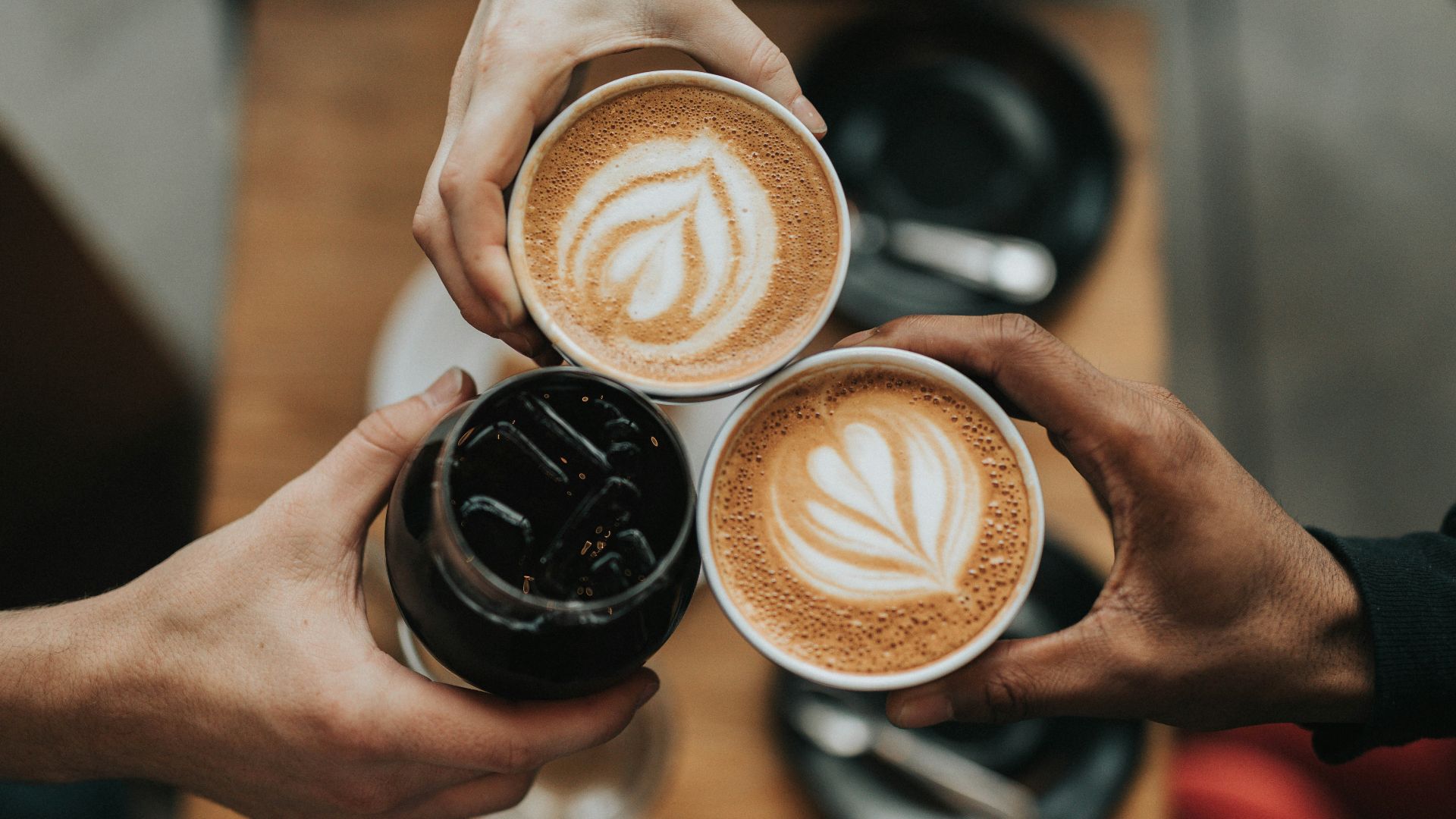 three person holding beverage cups