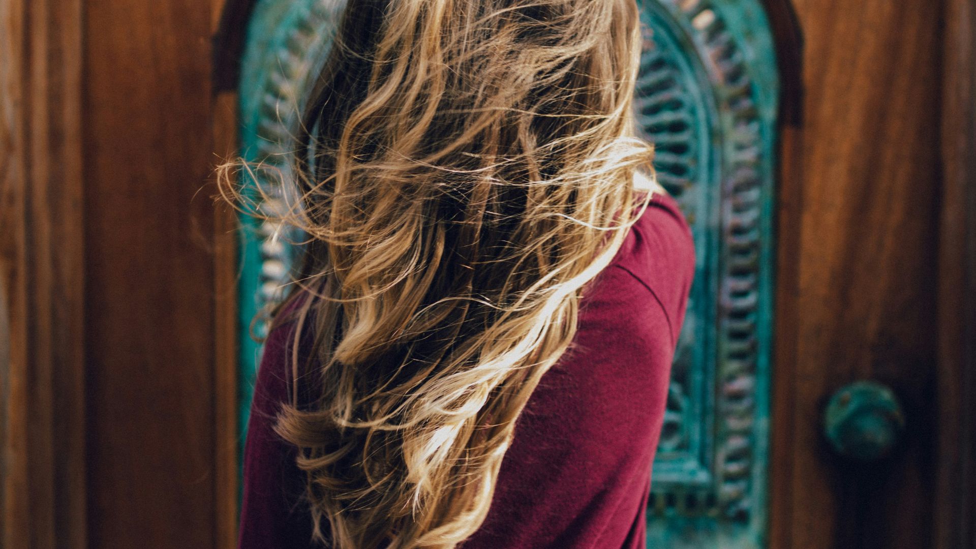 man wearing red sweater in front of door