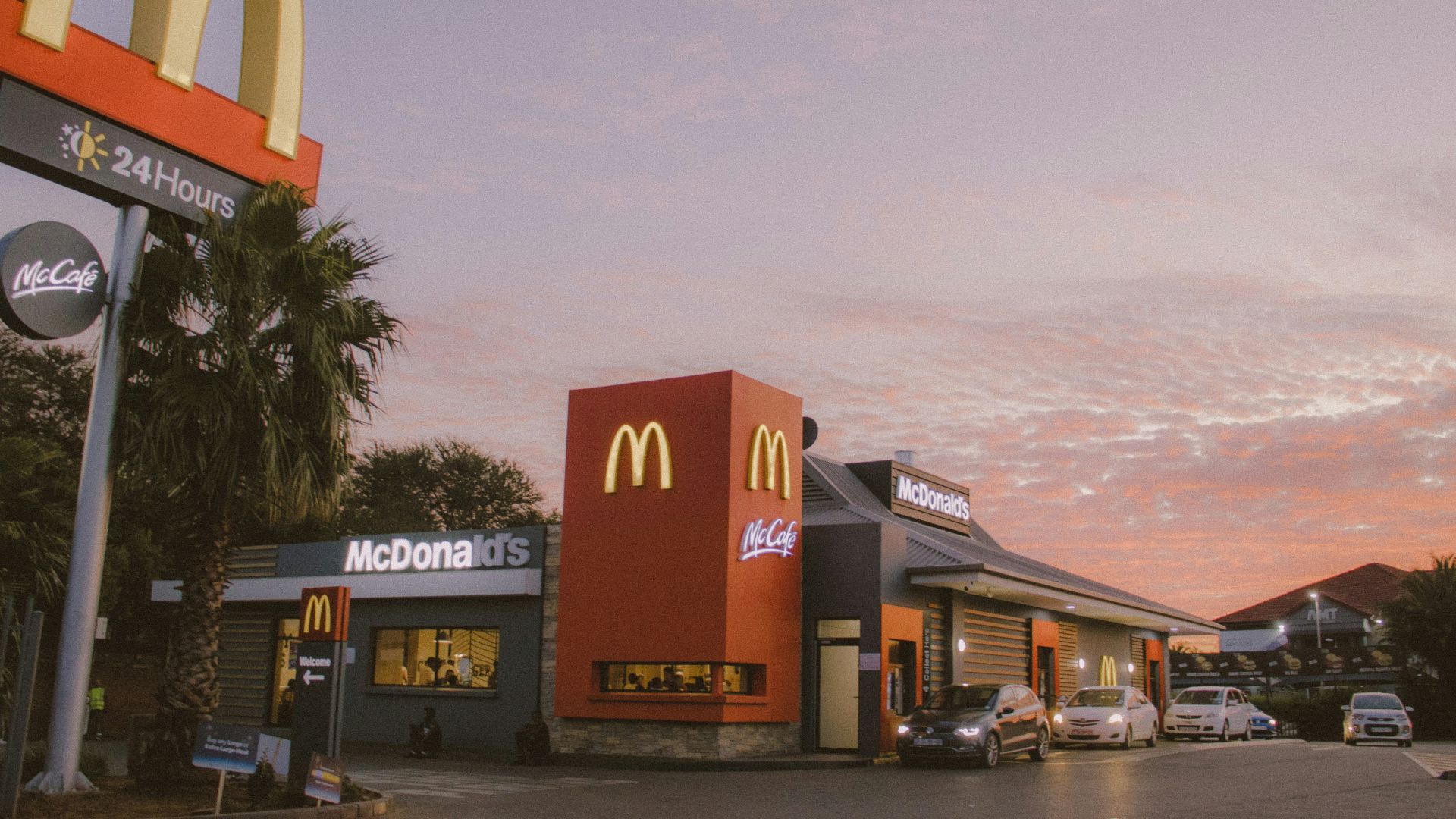 red and white concrete building near palm trees during daytime