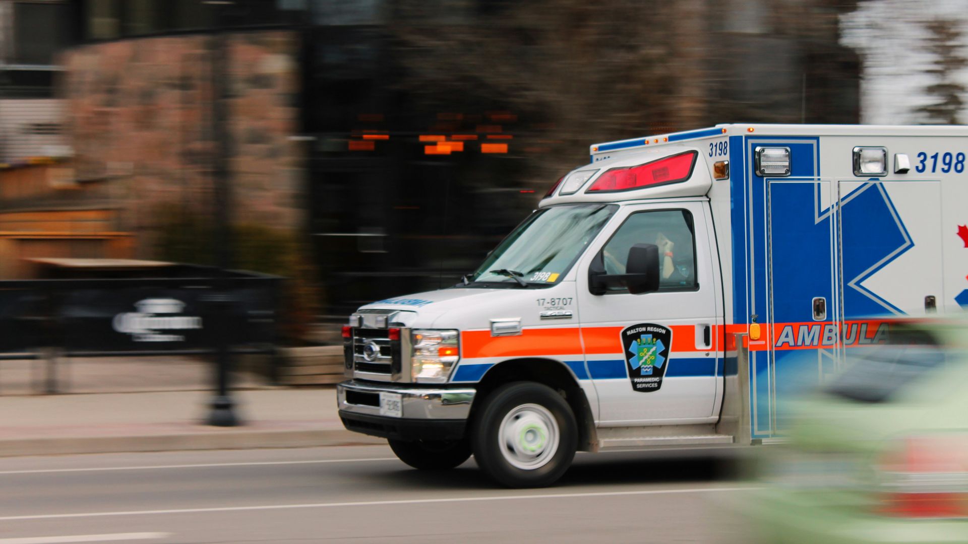 white and blue ambulance van traveling on road