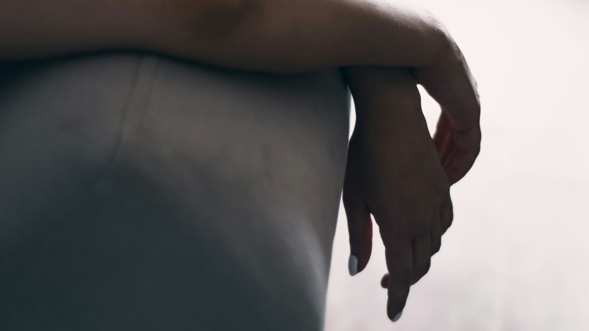 woman in black dress lying on gray couch