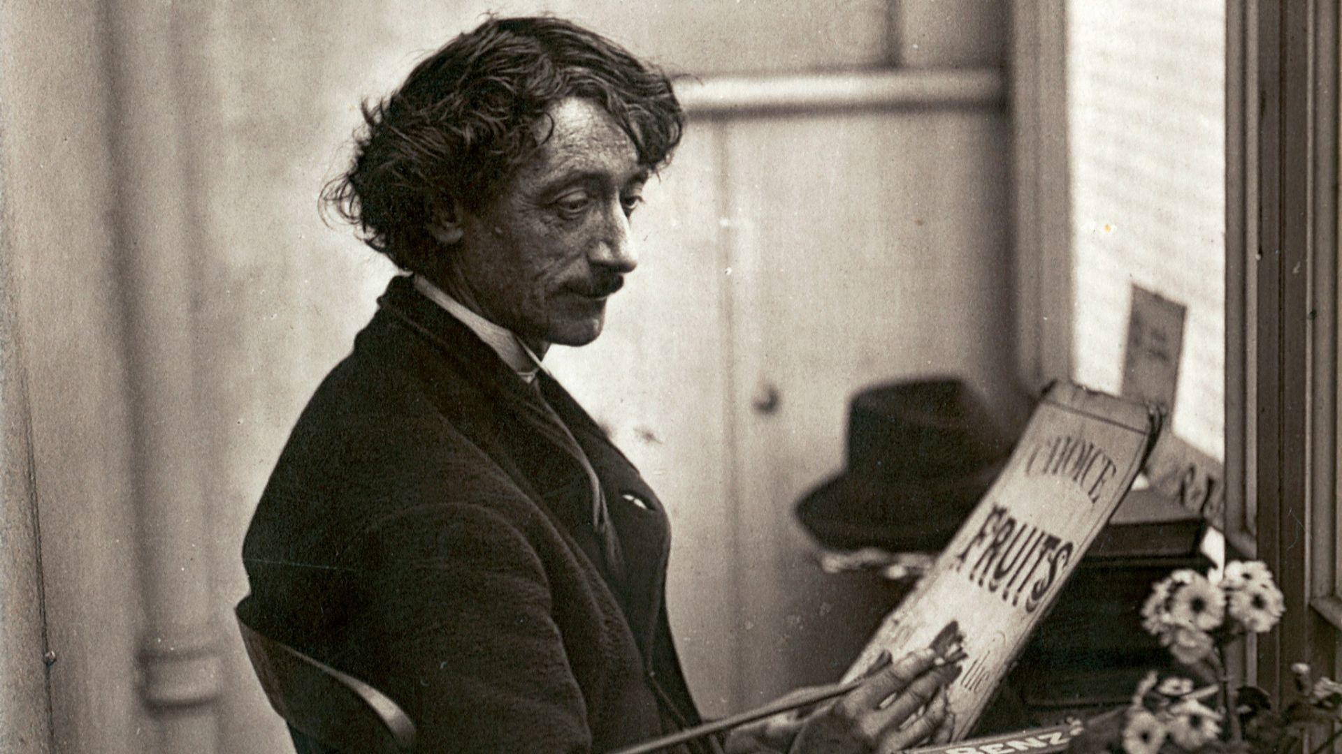 man in black suit jacket reading newspaper