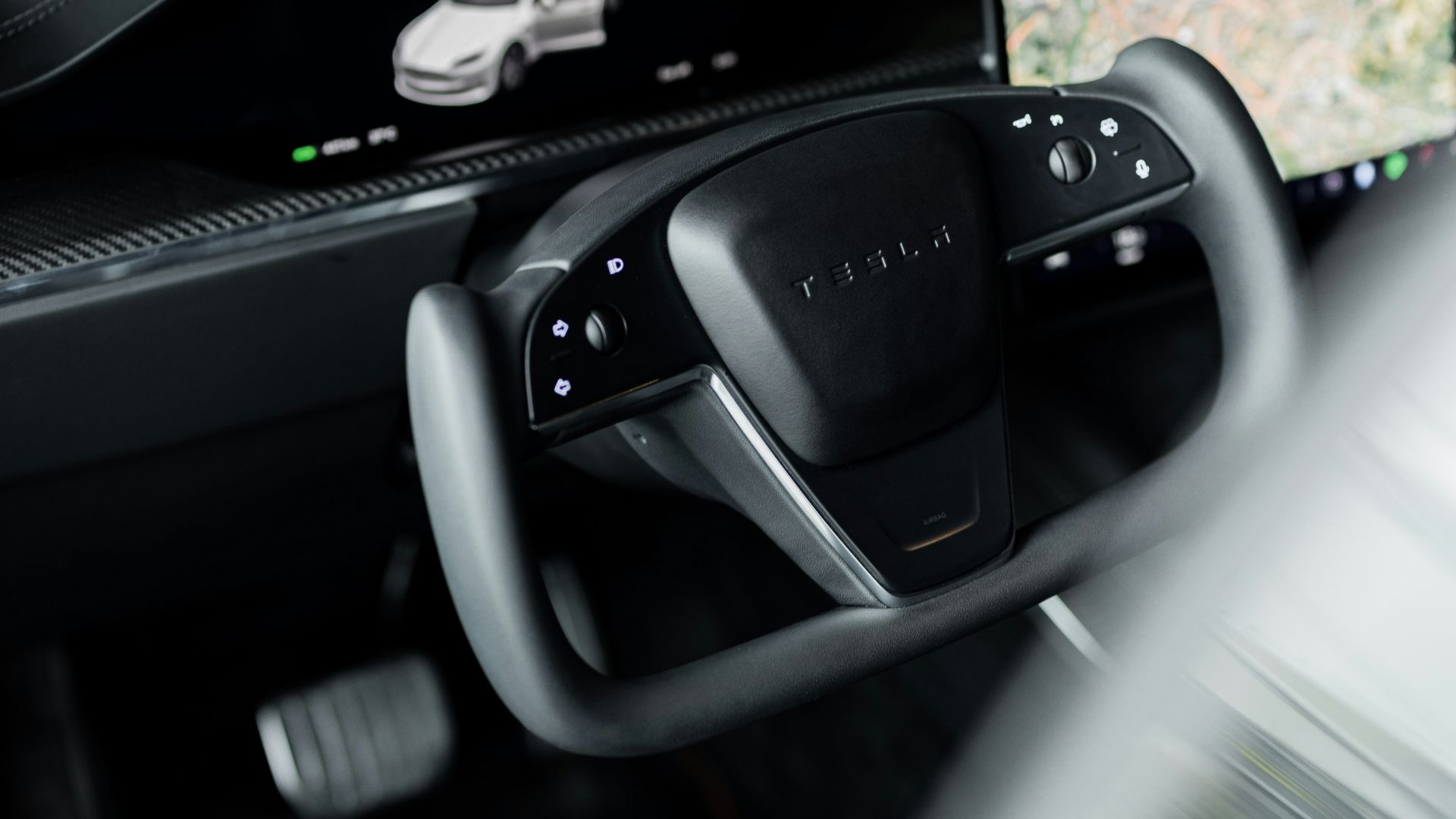a car dashboard with a monitor and a car steering wheel