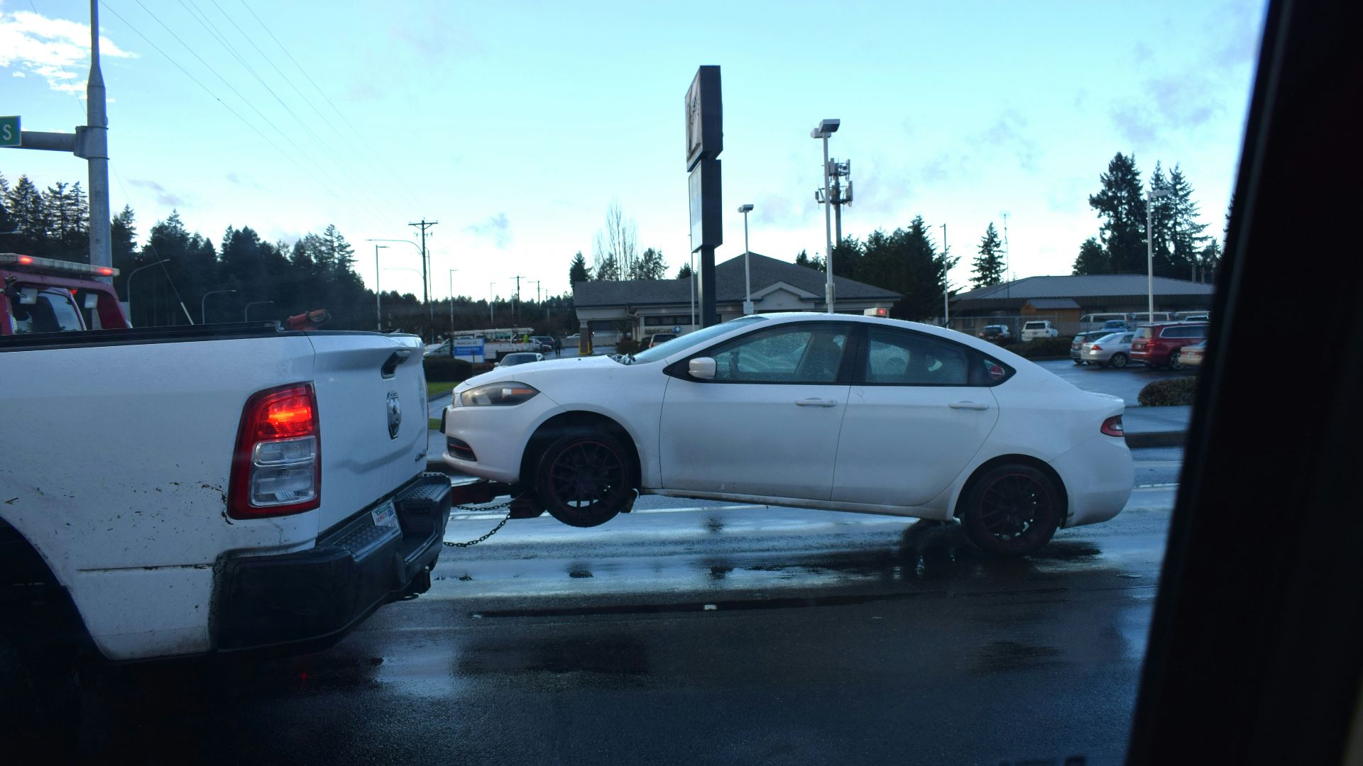 a white car being towed by a tow truck