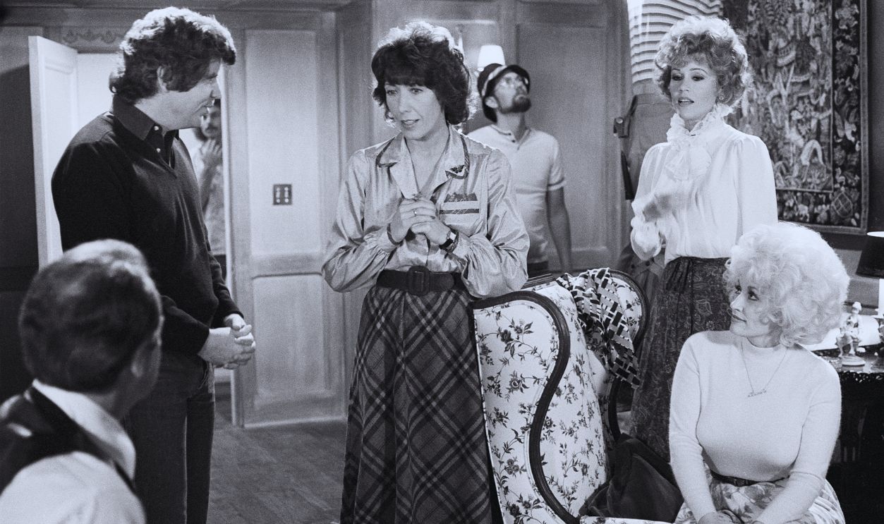 Gettyimages - 2233363130, Higgins, Tomlin, Fonda, & Parton On Set For '9 To 5' View of Australian-American film director Colin Higgins (1941 - 1988) (standing left) and American actors Lily Tomlin (hands clasped), Jane Fonda (standing right), and Dolly Parton on the set of the film '9 to 5' (also known as 'Nine to Five,' directed by Higgins), Los Angeles, California, 1979