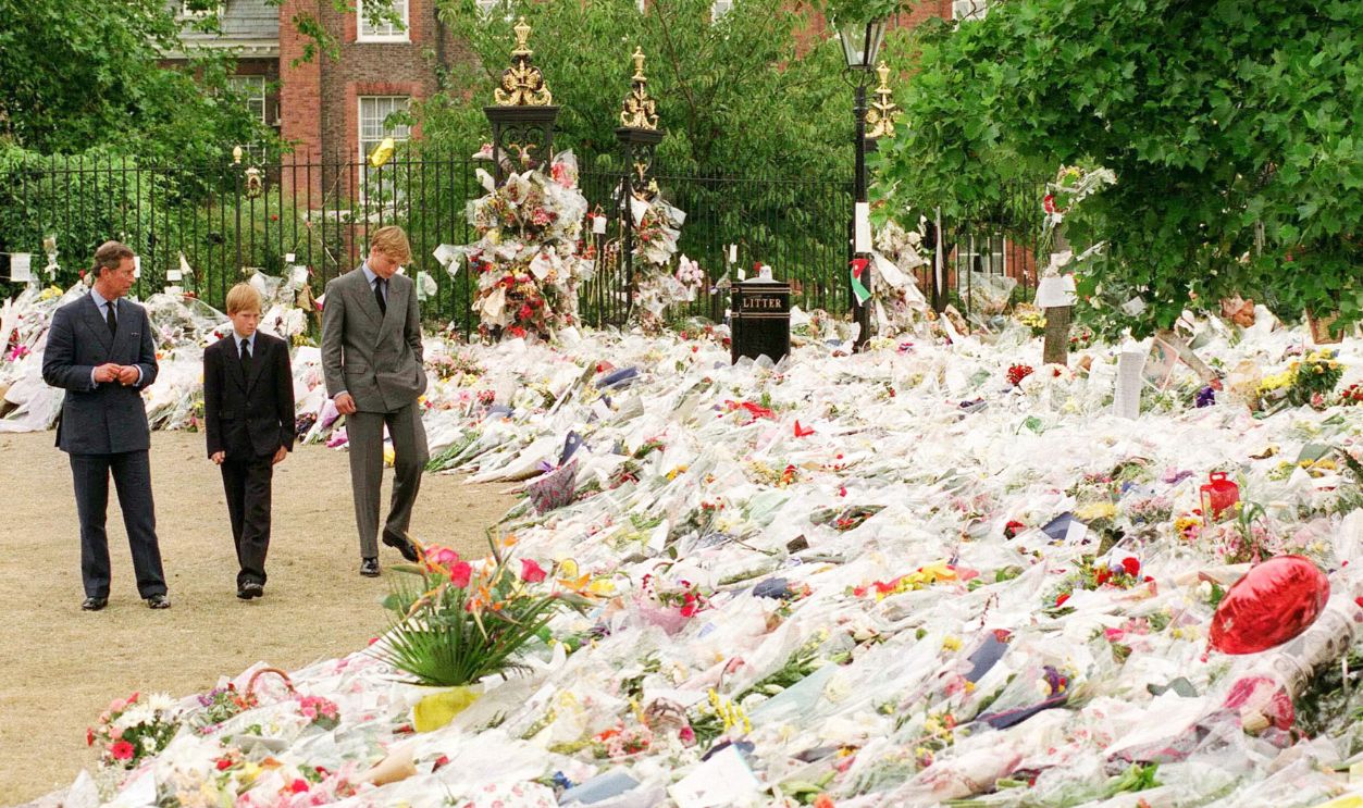 Prince William, Prince of Wales, with his sons Princes William and Harry looking at floral tributes left at Kensington Palace following the death of Diana, Princess of Wales in September, 1997. 