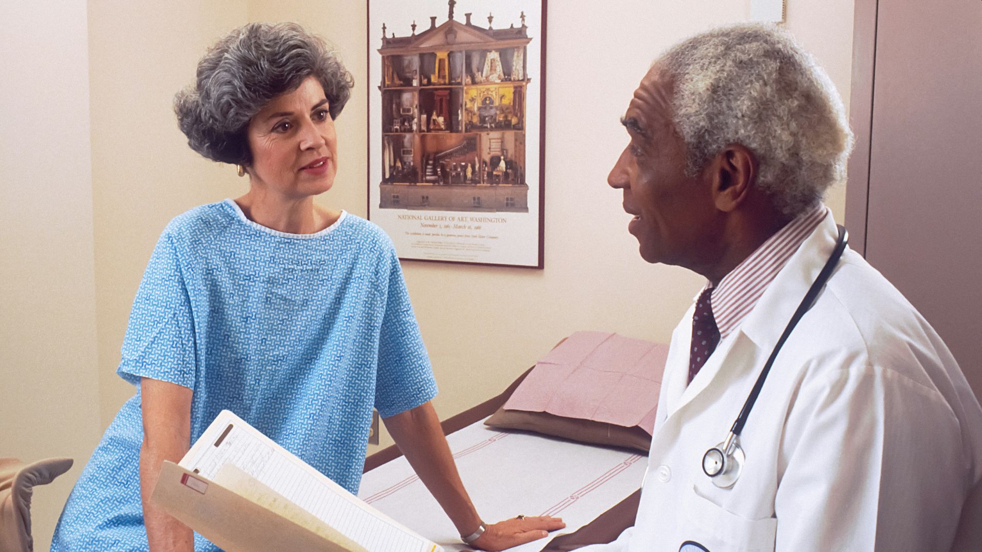 man in blue crew neck t-shirt holding white printer paper