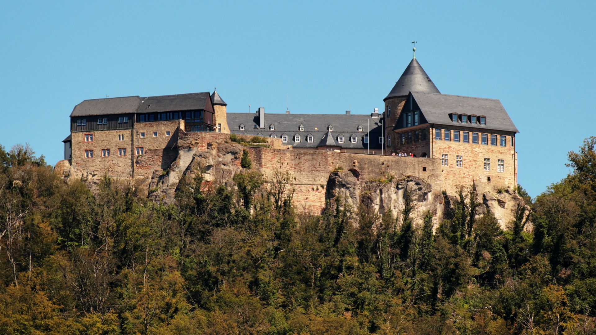 a castle on top of a hill surrounded by trees