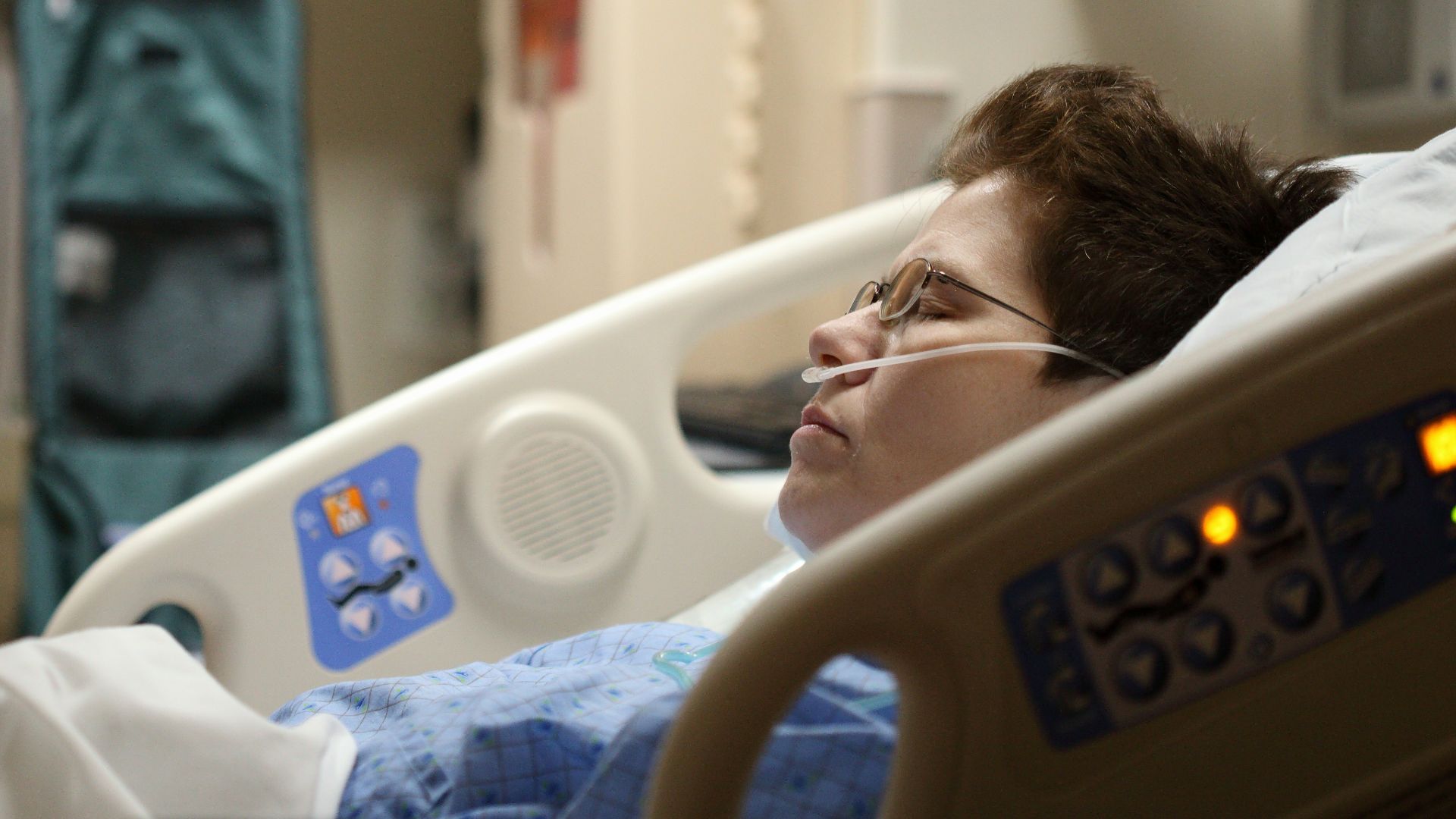 boy lying on beige recliner hospital bed