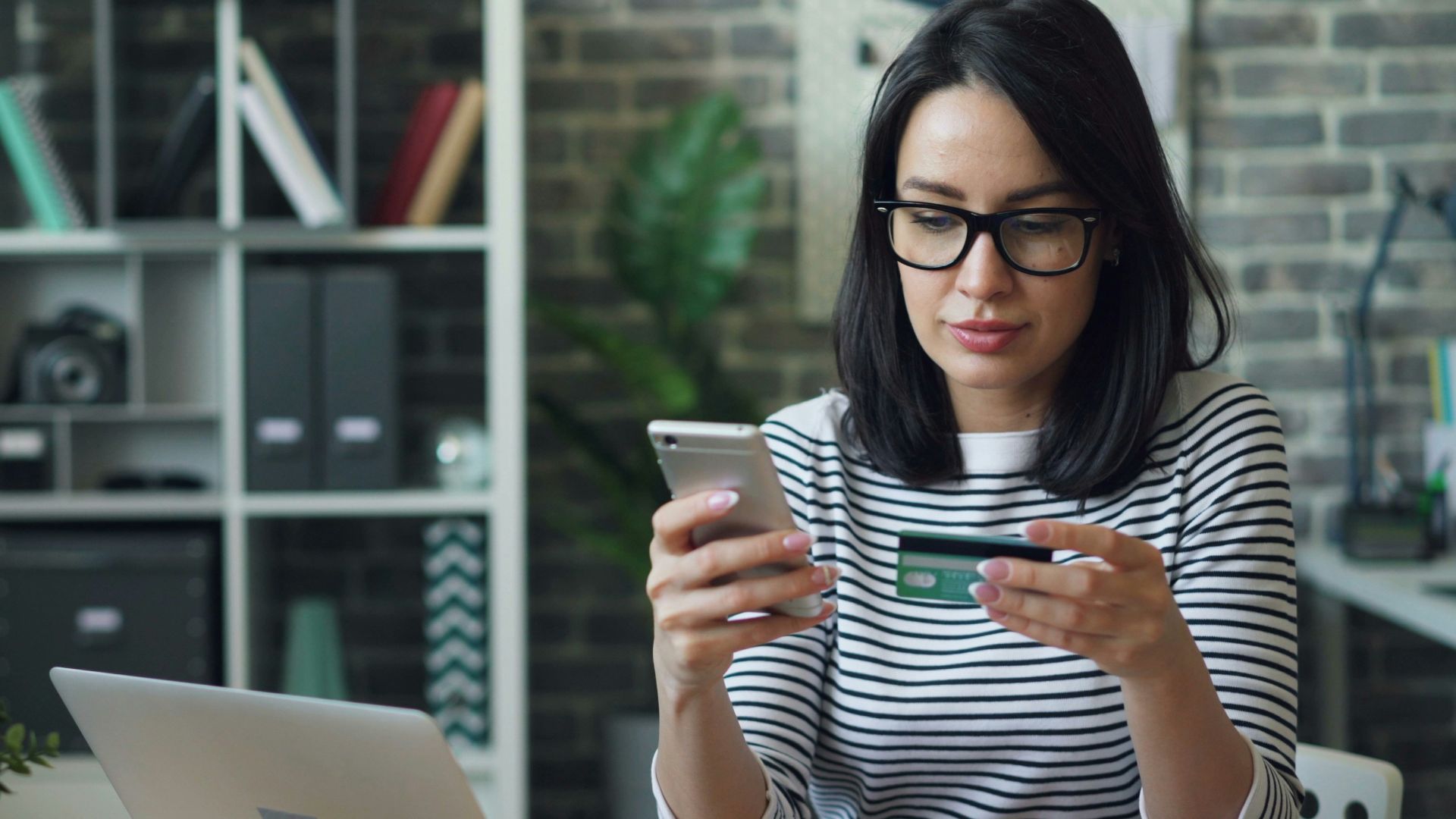 a woman sitting at a table looking at her cell phone