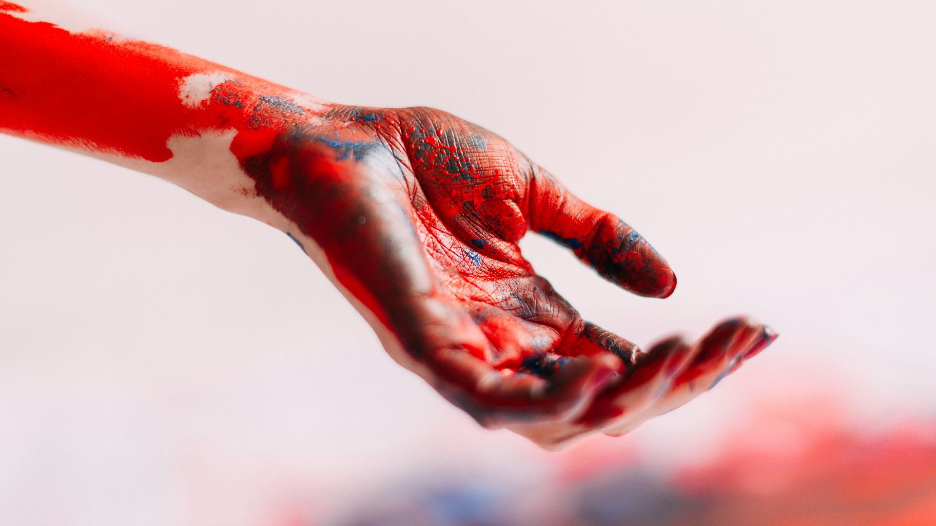 a person's hand with red and white paint on it