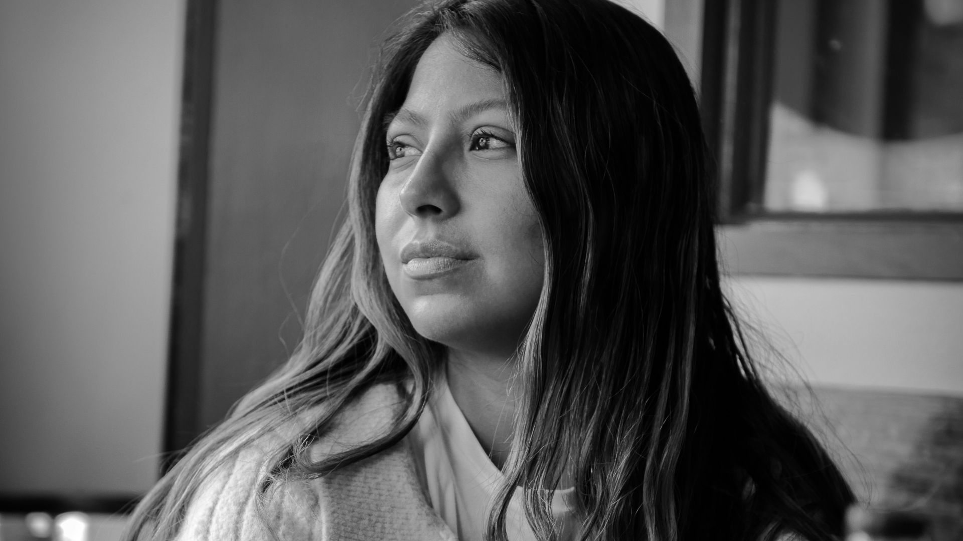 a black and white photo of a woman sitting at a table