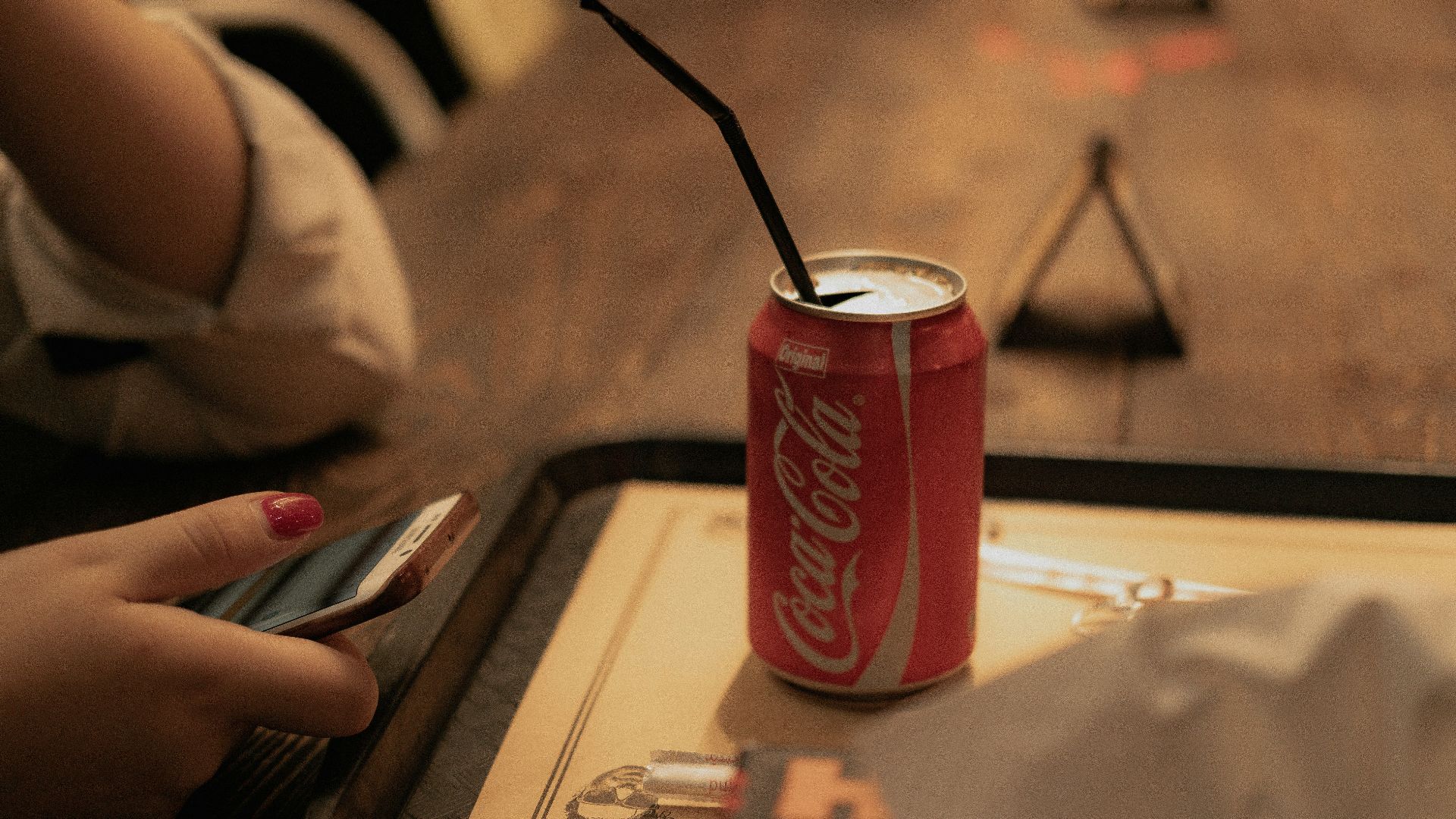 a can of coca cola sitting on top of a wooden table