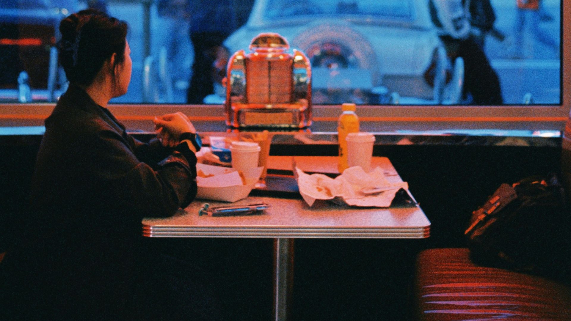 a woman sitting at a table in front of a window