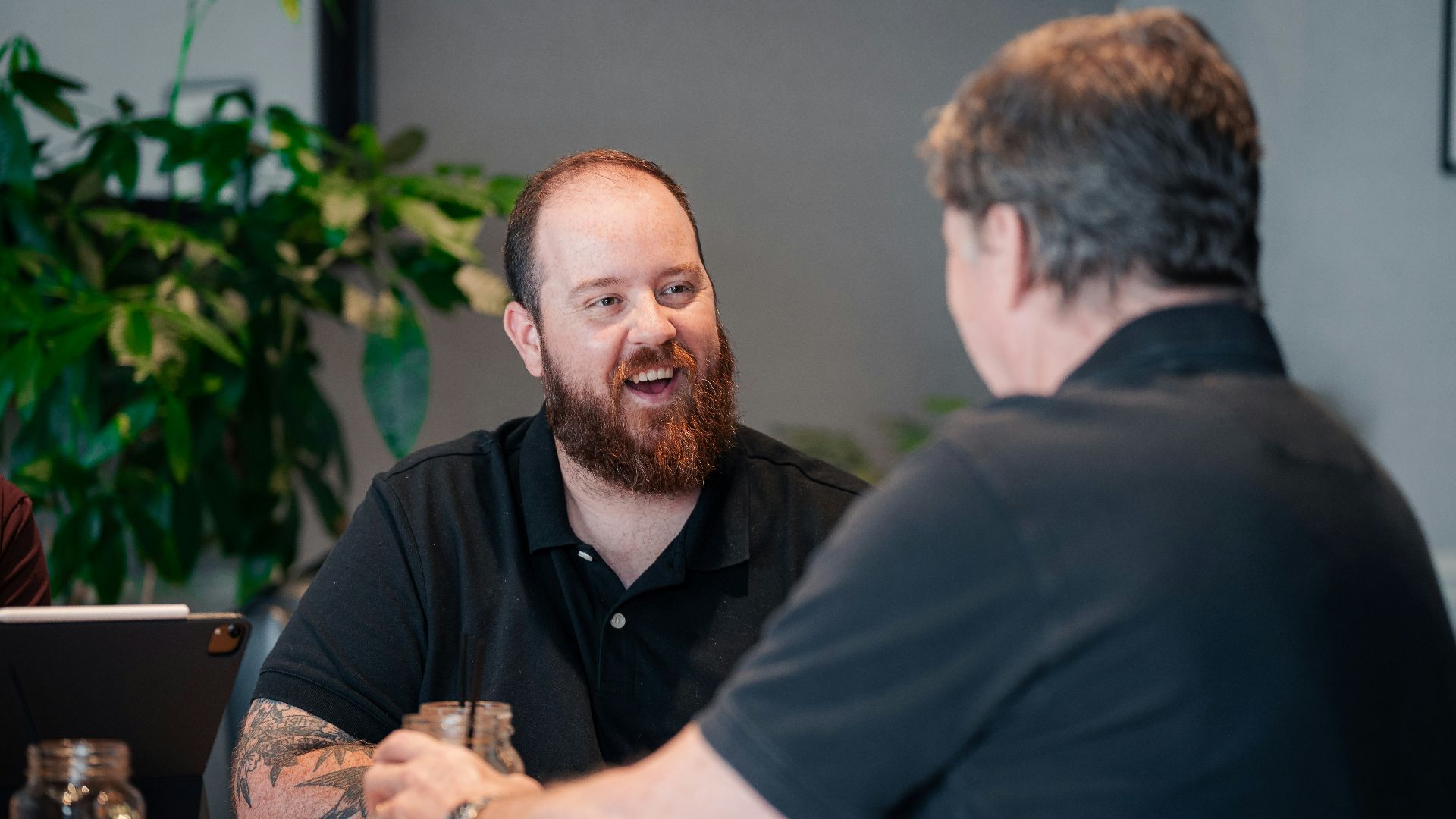 two men sitting at a table talking to each other