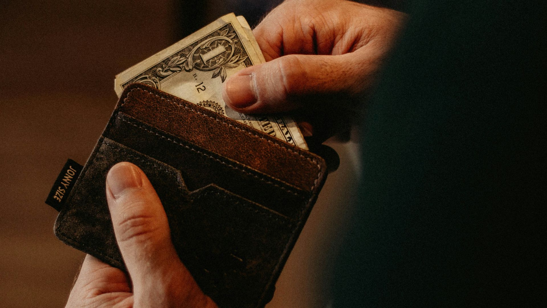 person getting 1 U.S. dollar banknote in wallet