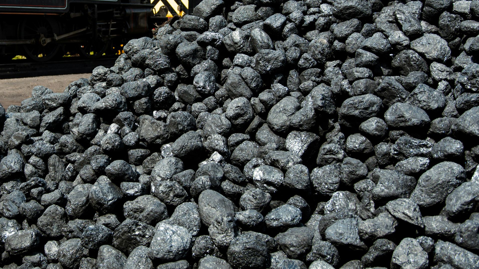 a train traveling past a pile of coal