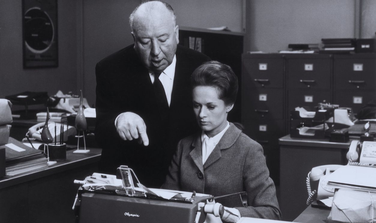 Gettyimages - 3244935, Marnie 1964: British director Alfred Hitchcock (1899 - 1980) directs American actor Tippi Hedren while she sits in front of a typewriter on the set of his film, 'Marnie'. 