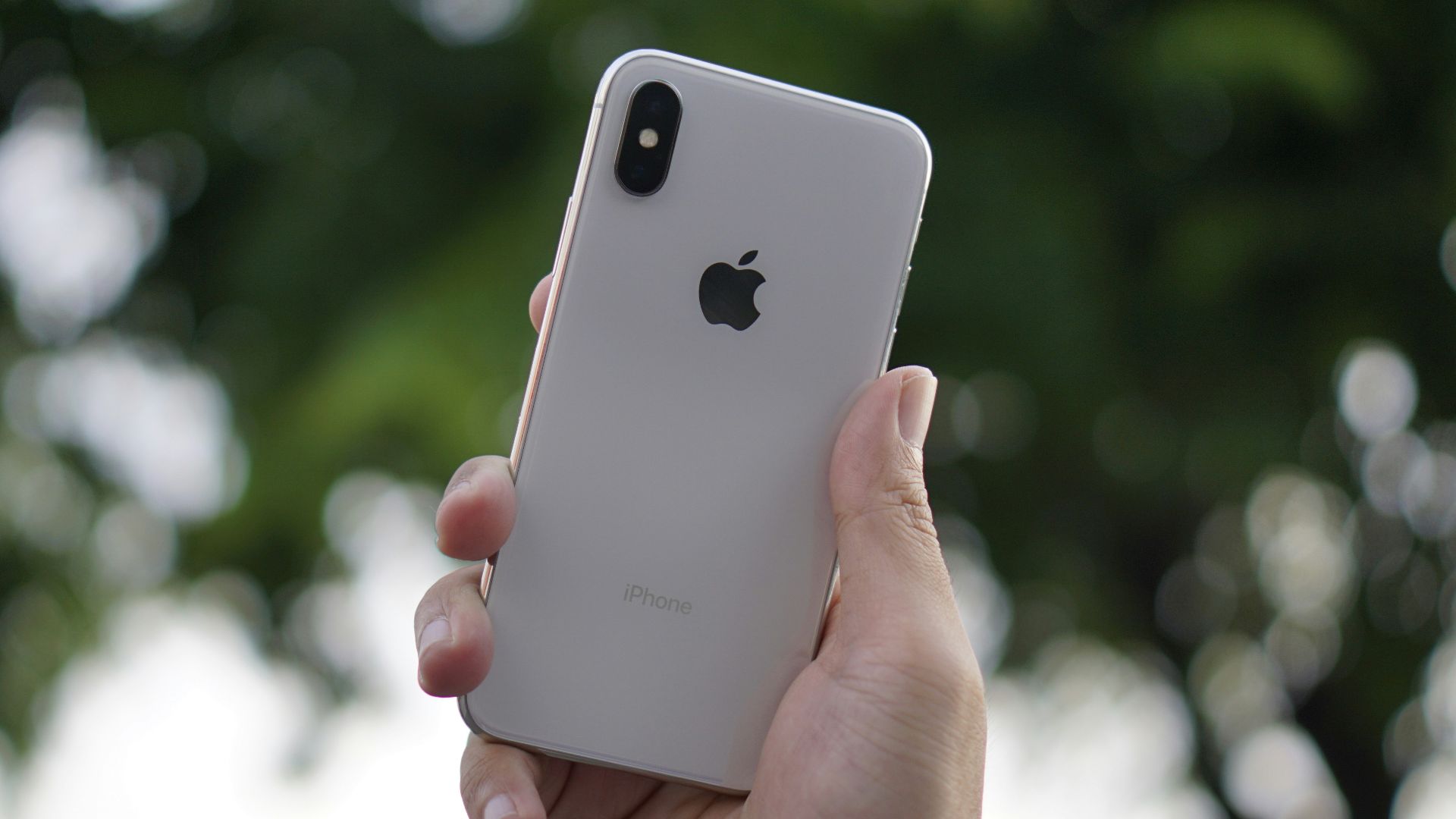 person holding silver iPhone X during daytime