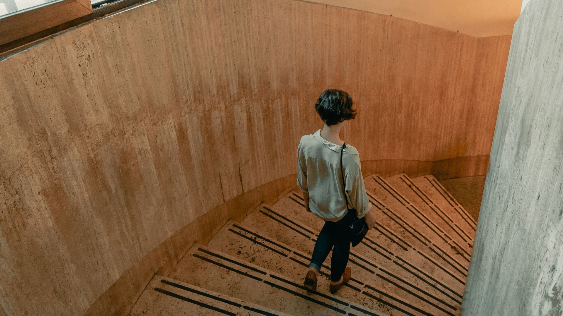 man in white dress shirt sitting on brown wooden floor