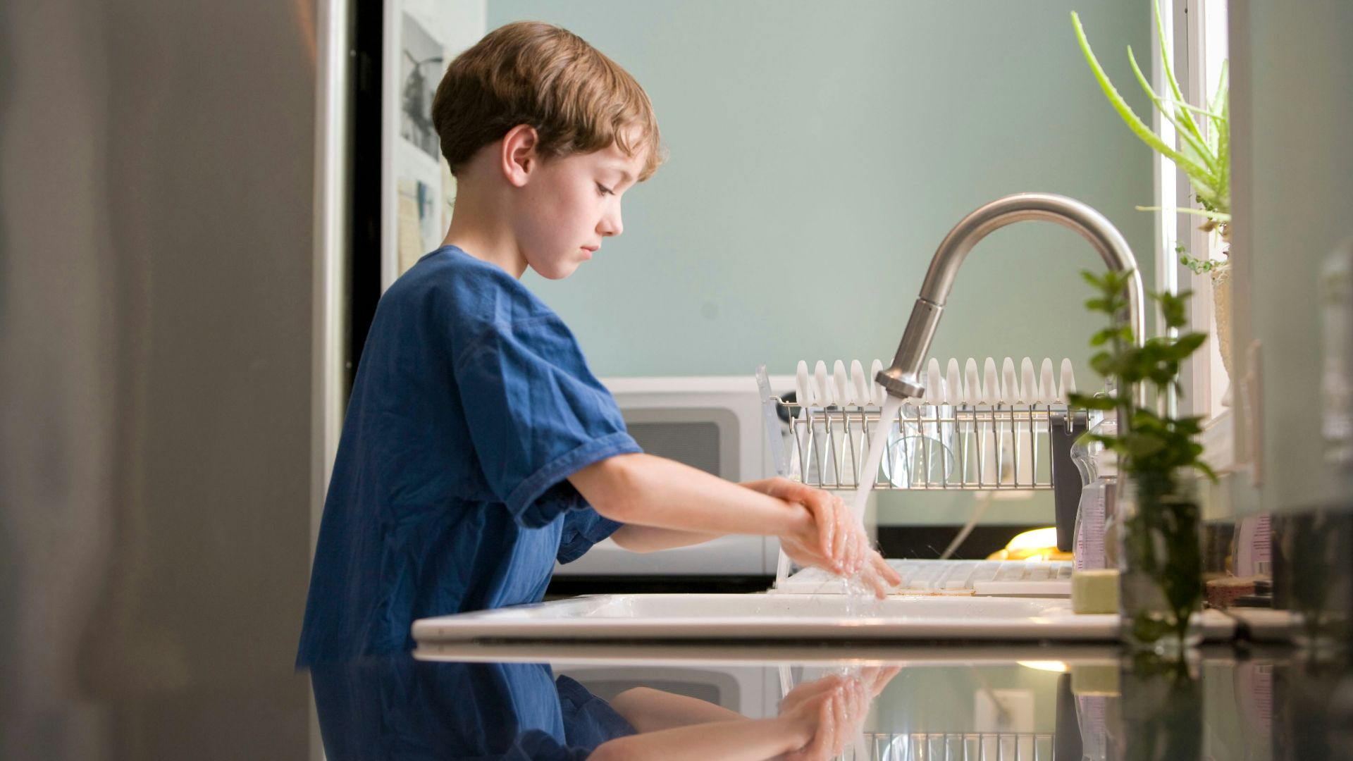 boy in blue crew neck t-shirt standing beside white wooden door