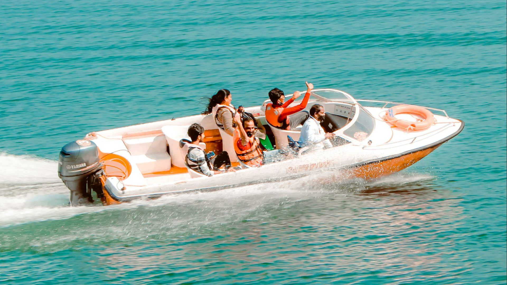 2 people riding on white and red inflatable boat on blue sea during daytime