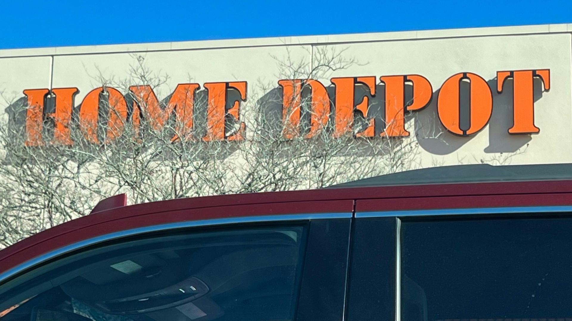 a red car parked in front of a home depot