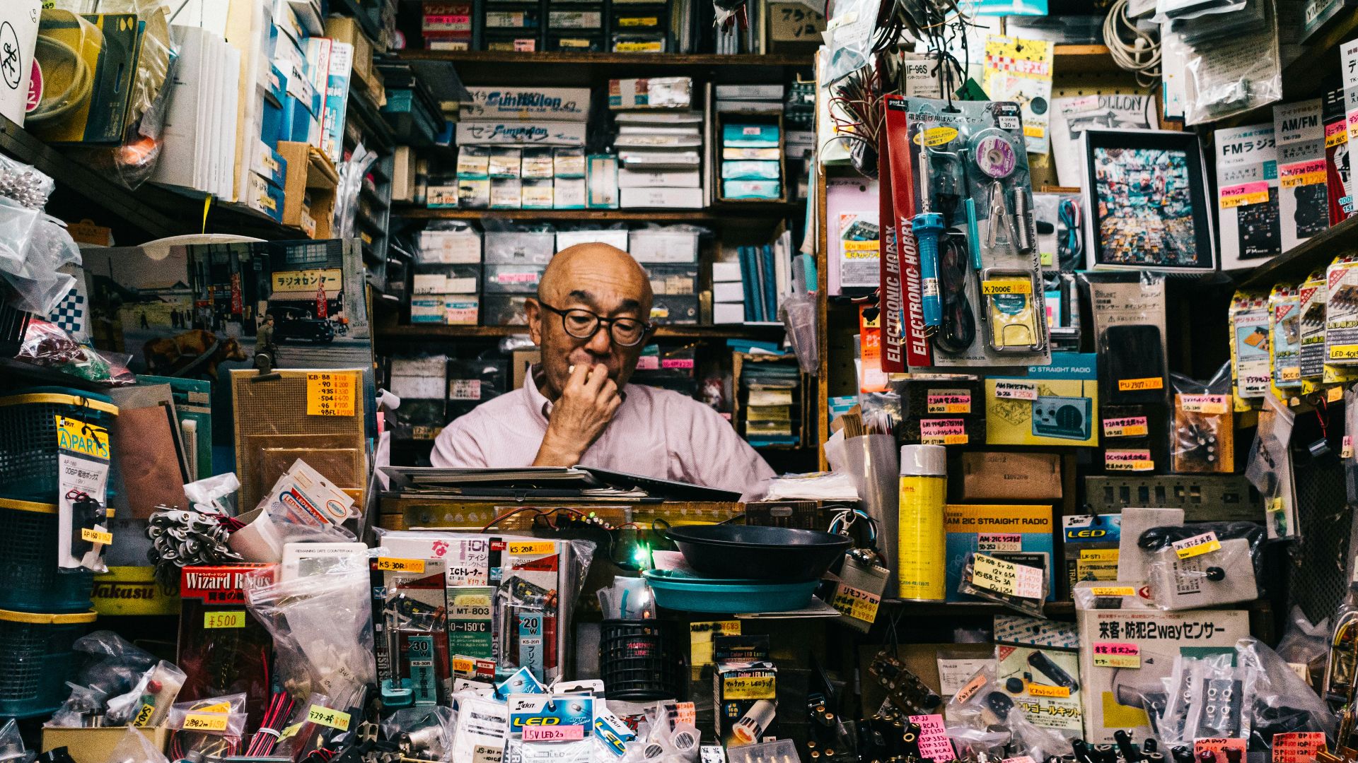 man standing beside assorted-color electronic and accessory packs