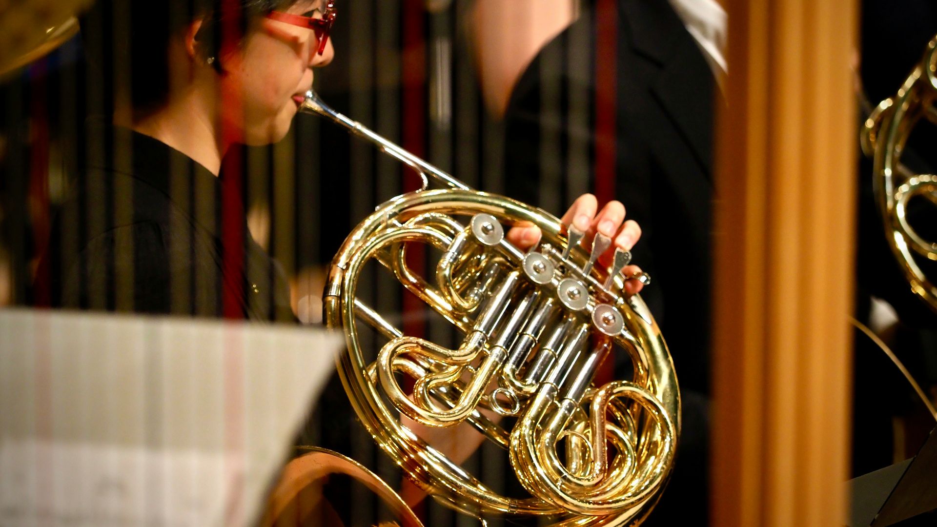 woman in red shirt playing brass trumpet
