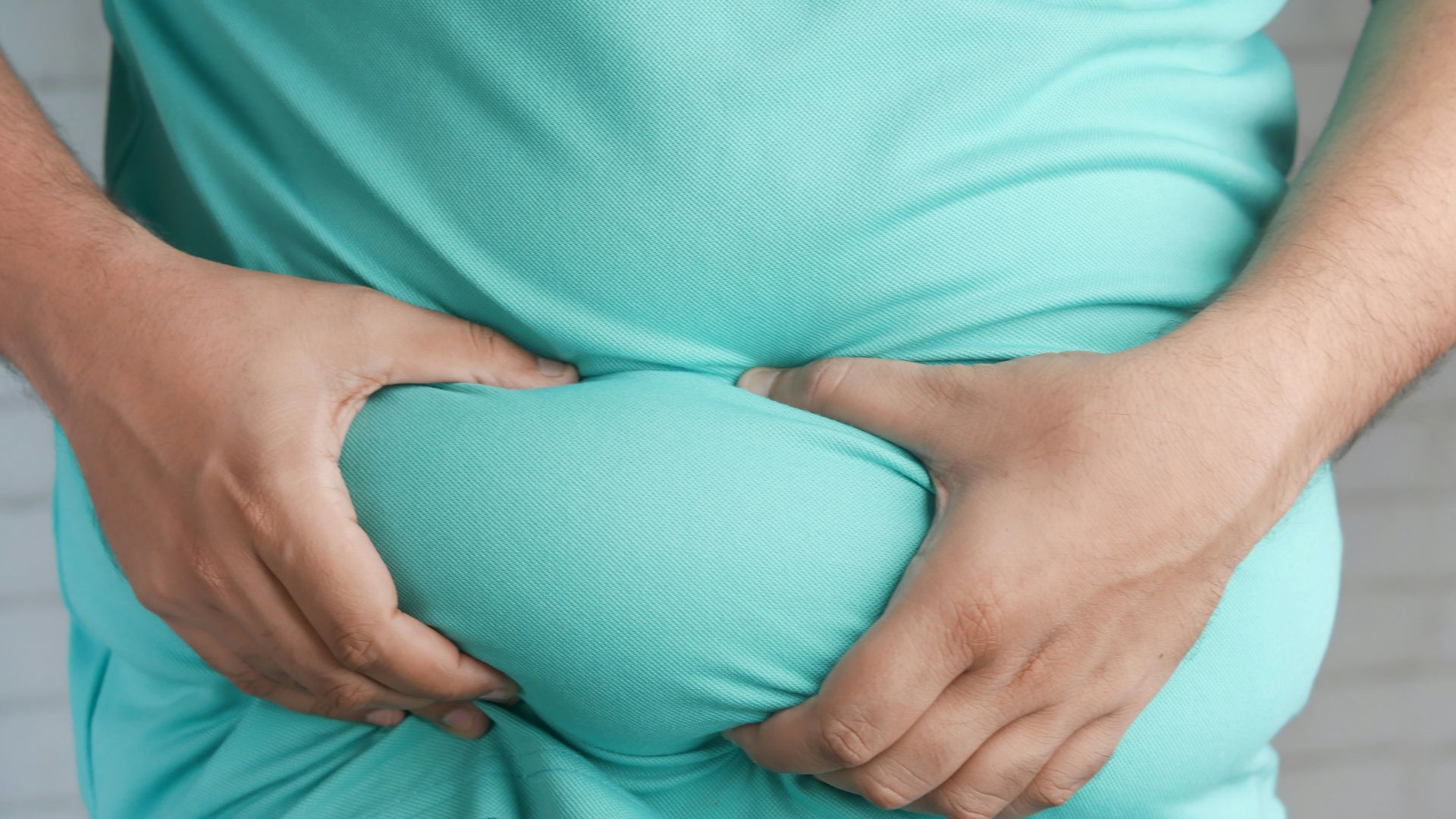 a man holding his stomach with his hands