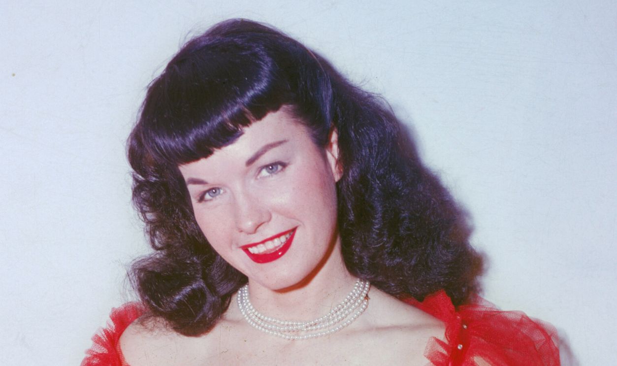 Gettyimages - 71654779, Bettie Page American glamour model and pin-up girl Bettie Page poses in a red negligee and stockings, circa 1955. 