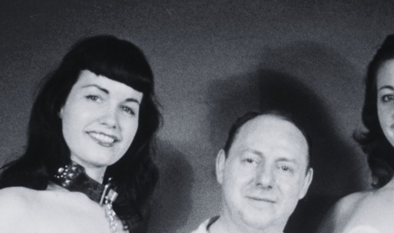 Gettyimages - 84080096, Bettie And Irving American model Bettie Page (1923 - 2008, left) poses with photographer Irving Klaw (1910 - 1966) and another model, circa 1955. Bettie is wearing a makeshift chastity belt. 