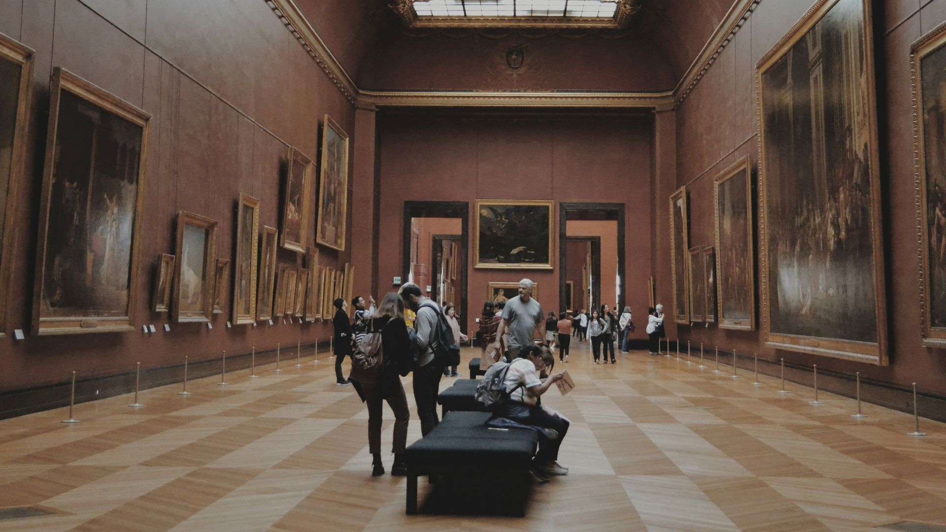 people walking on corridor looking at painting