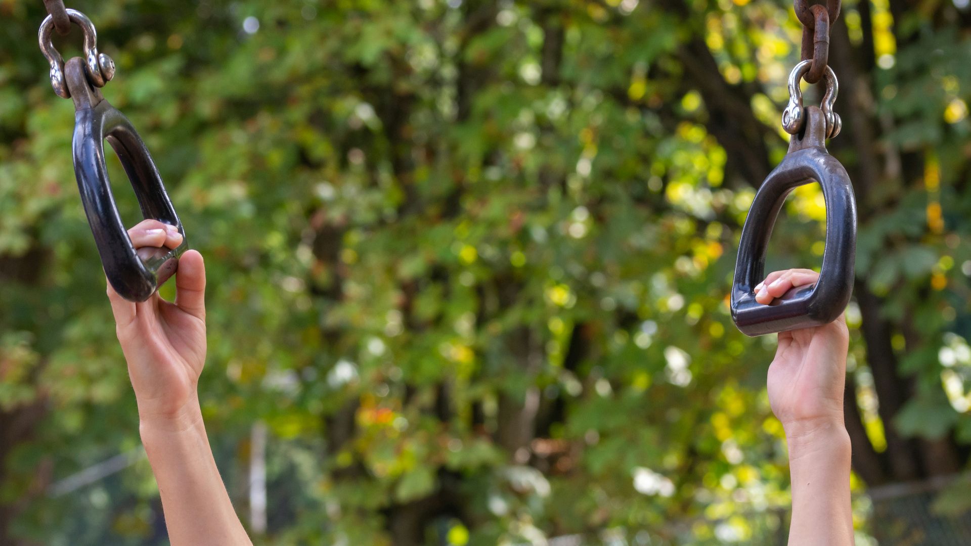 a person holding onto a swing in a park