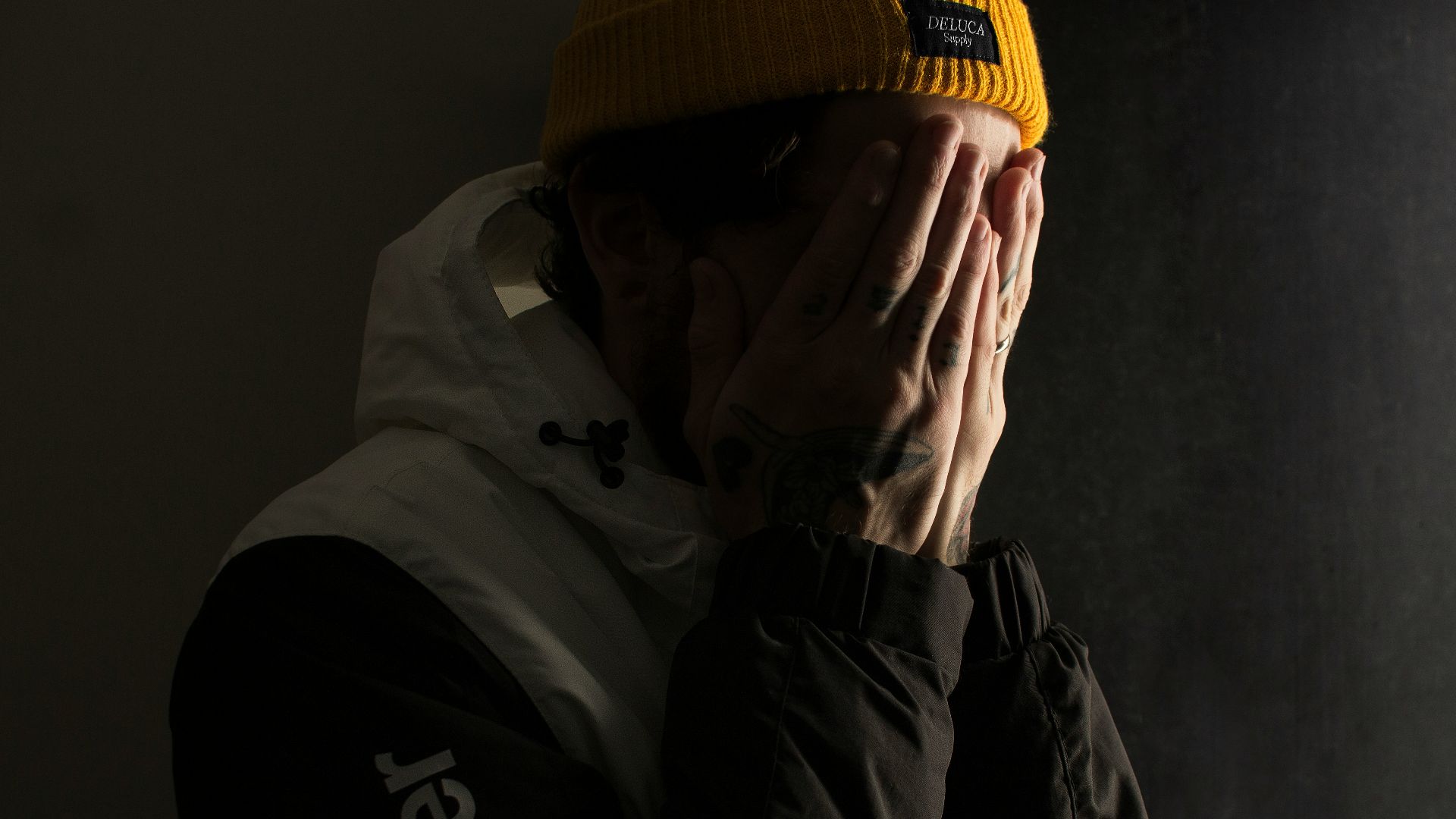 man covering his face with both hands