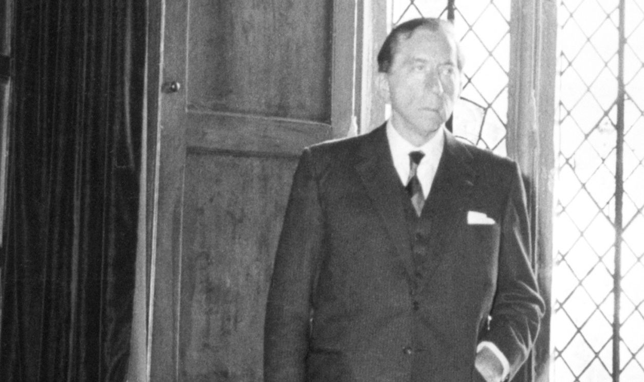 1959-Jean Paul Getty poses before one of the windows of Sutton Place, the Duke of Sutherland's estate, before buying it.