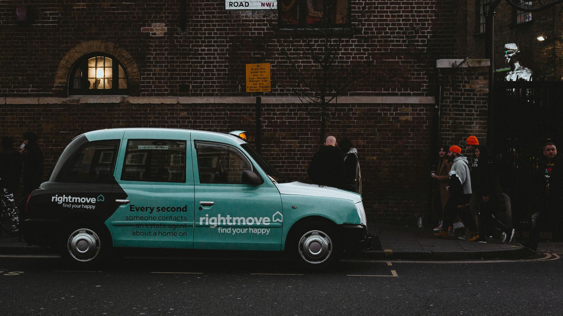 white and black volkswagen t-1 parked beside brown brick building during daytime