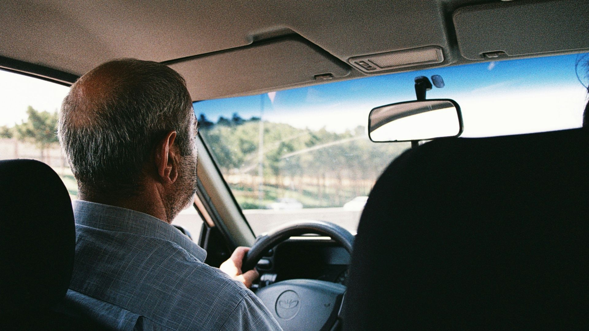 a man driving a car down a street