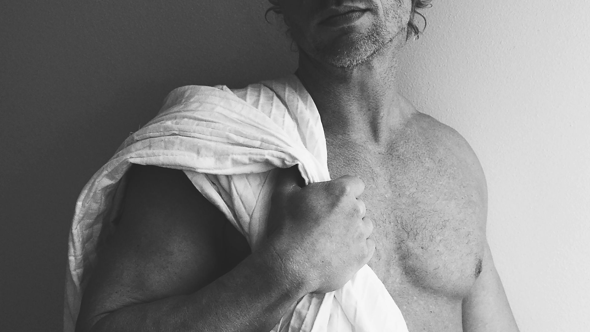 man in white towel in grayscale photography