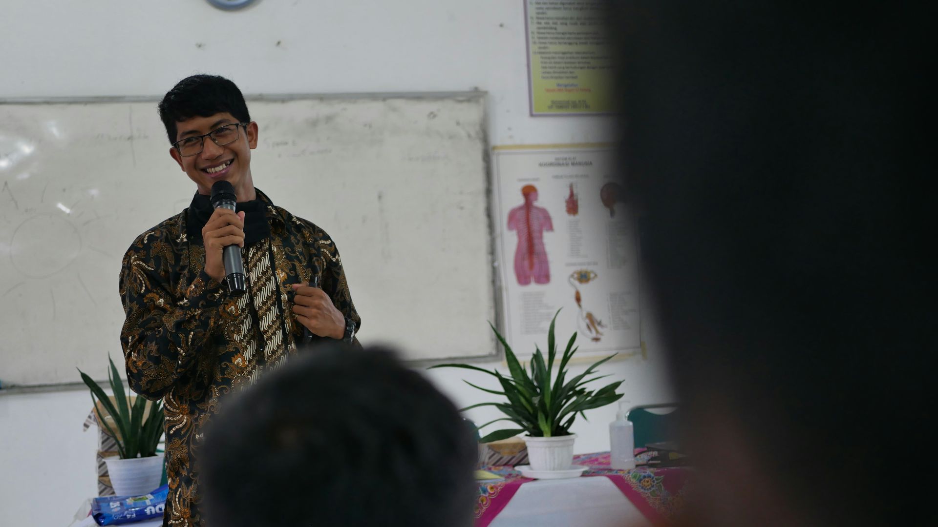 a man standing in front of a mirror holding a microphone