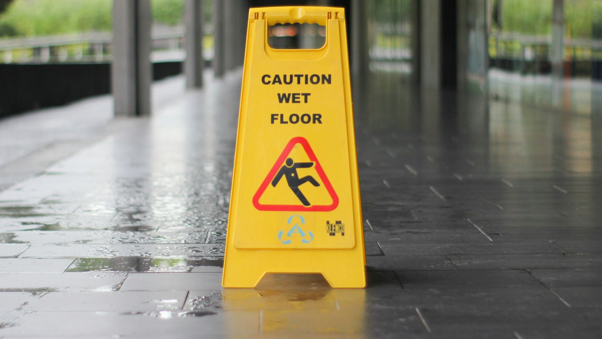 yellow Caution wet floor signage on wet pavement
