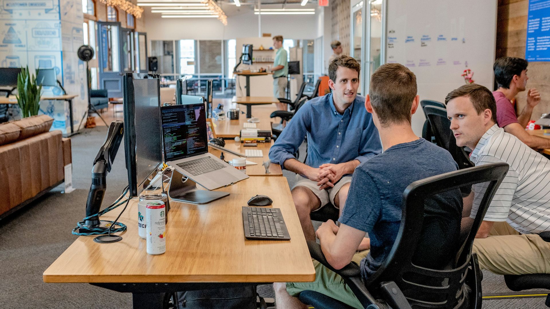 three men sitting on chair beside tables