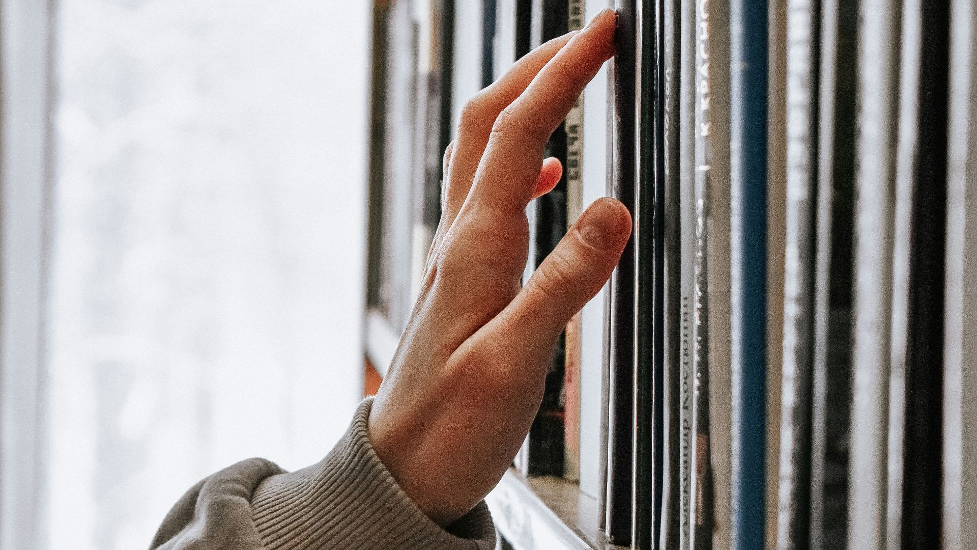 person in white long sleeve shirt holding white book