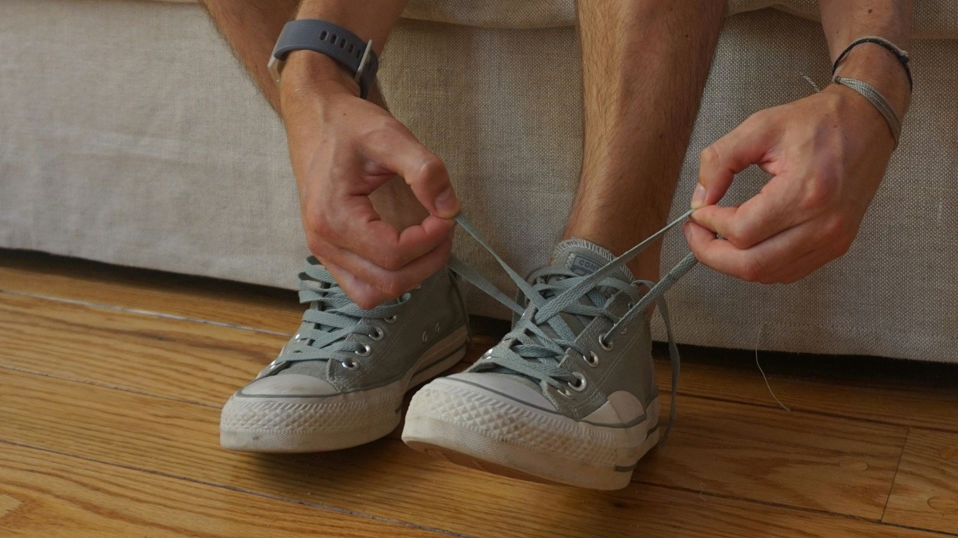 a man sitting on a couch holding his shoes