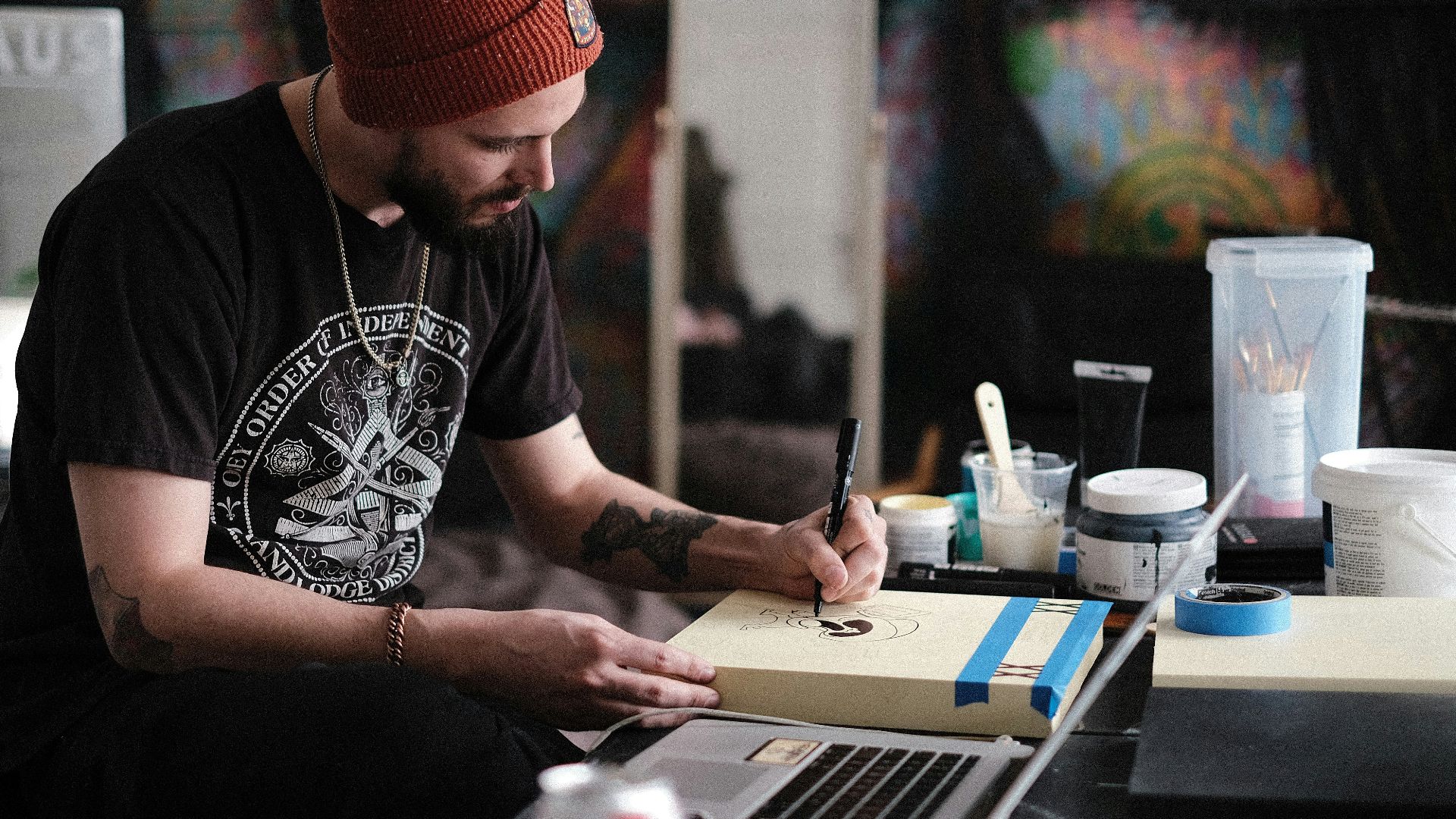 a person with a red hat writing on a laptop