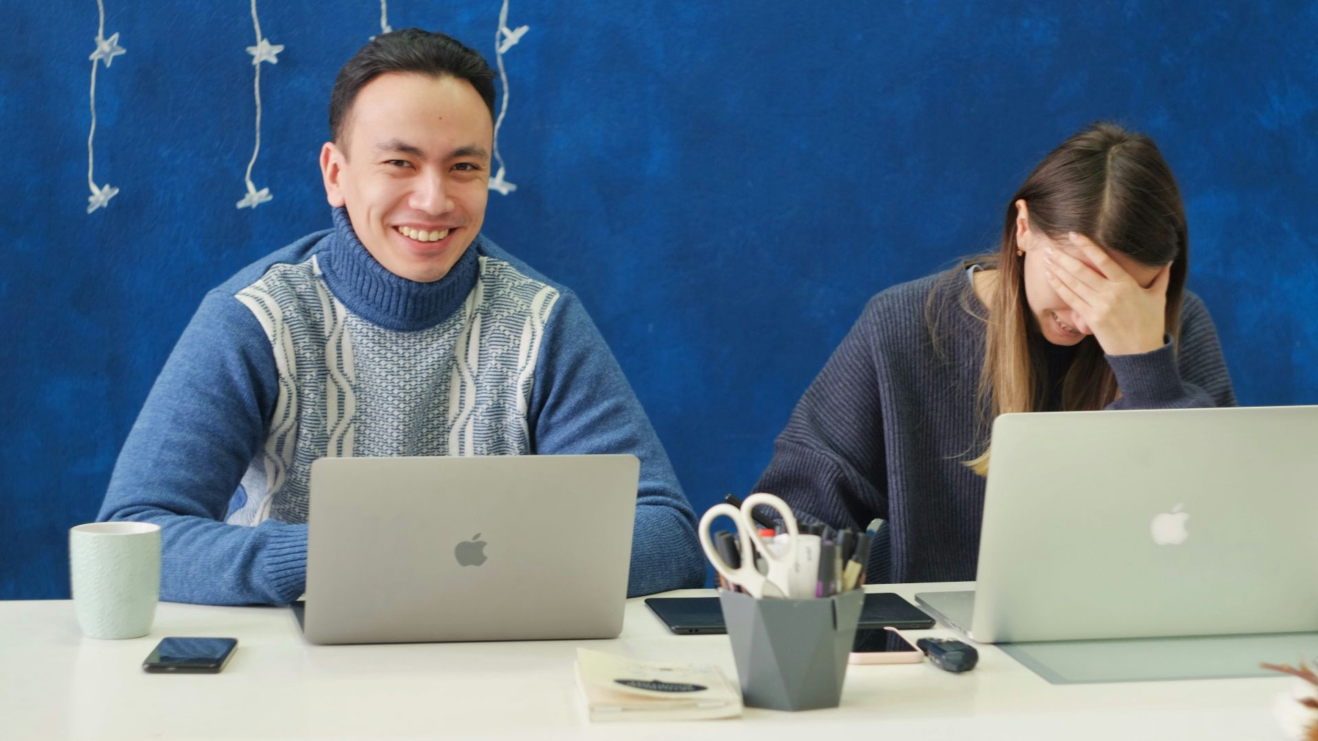 woman in gray sweater using silver macbook