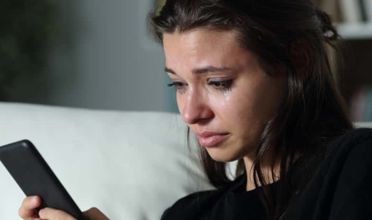 Sad Teenage Girl Checking Smart Phone -Shutterstock 1469026343