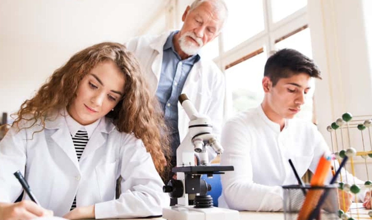 Senior Teacher Teaching Biology To High School, Shutterstock, 705161482